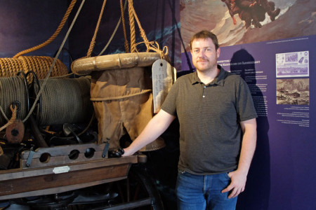 Museumsleiter Christoph Wegner vor einem alten Leinenrettungswagen aus dem Jahr 1873. Das gute St&uuml;ck hat in der neu gestalteten Dauerausstellung selbstverst&auml;ndlich einen Platz gefunden.