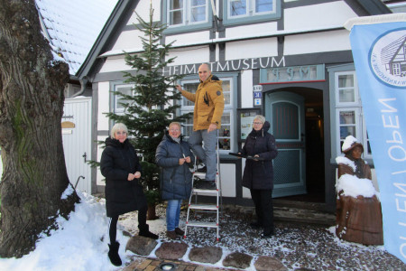 Jutta Weidemann, Sabine Engel, Igor Milanovic und Hanne Hoppe (v.l.) schmücken den Baum vor dem Heimatmuseum Warnemünde.// Foto: Christoph Wegner