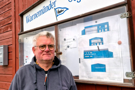 Vereinsvorsitzender Torsten Schranck pr&auml;sentiert vor dem Schaukasten die Pl&auml;ne f&uuml;r das neue &bdquo;Uns Logis&ldquo; auf der Warnem&uuml;nder Mittelmole &ndash; ein Millionenprojekt f&uuml;r die Zukunft des Warnem&uuml;nder Segel-Clubs.