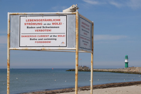 Dieses Hinweisschild soll Badegäste auf die Gefahren im Bereich der Warnemünder Westmole aufmerksam machen.