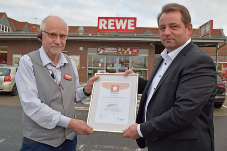 Rewe-Marktleiter Klaus-Dieter Strelau (l.) freut sich über die erneute Zertifizierung, überreicht durch Kay-Uwe Teetz vom Handelsverband Nord.