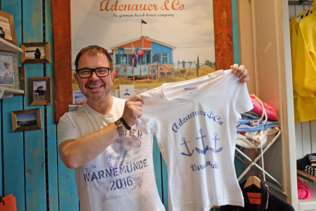 Jens Kunze freut sich auf das Ostergeschäft: Jeweils 100 Warnemünde-Shirts für Damen und Herren sind im Adenauer & Co Strandhaus am Leuchtturm zu haben.