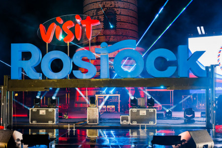 Ein Moment zum Festhalten: Der Visit-Rostock-Fotospot beim stimmungsvollen Turmleuchten, positioniert vor dem Warnem&uuml;nder Leuchtturm.//Foto: Holger Martens