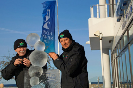 Bei strahlendem Sonnenschein arbeiten Othmar Schiffer-Belz (li.) und der Künstler Andrius Petkus an der Skulptur "Bubbles In Ice".