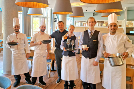 Hoch motiviert starten die neuen Nachwuchskr&auml;fte im Hotel H&uuml;bner Warnem&uuml;nde ins Berufsleben. Stellvertretend f&uuml;r den Ausbildungsjahrgang sind (v.l.) Aymen Alhammad, Ibrahim Almohamad, Jolina Tometzki, Hoteldirektor Christoph G&auml;bler (3.v.l.), Hielke Sonnevelt und Ali Mohammed Al-Askari zu sehen.//Foto: Hotel H&uuml;bner, Christin P&uuml;ngel
