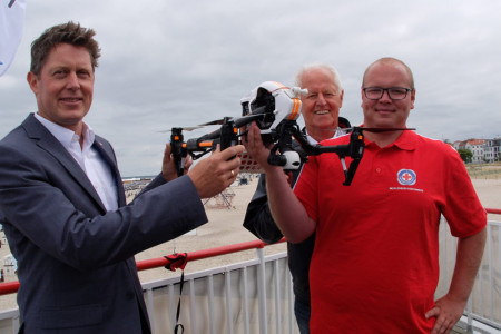 Pr&auml;sentieren den ersten Rettungscopter am Strand von Warnem&uuml;nde: J&uuml;rgen Richter, Vorstandvorsitzender des DRK-Kreisverbandes Rostock, Pr&auml;sident Wilfried Kelch und &bdquo;Drohnen-Pilot&ldquo; Lukas Knaup (v.l.)
