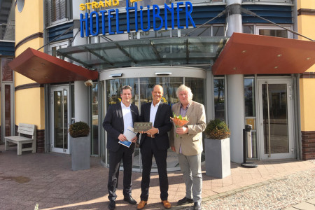 Kai Dau  (l.) und Axel Wojatzik (r.) beglückwünschen den Hoteldirektor vom Strand-Hotel Hübner, Dietmar Karl.
