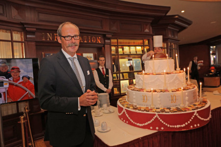 Hotelmanager Harald Schmitt hat allen Grund zur Freude und präsentiert stolz die Jubiläumstorte.