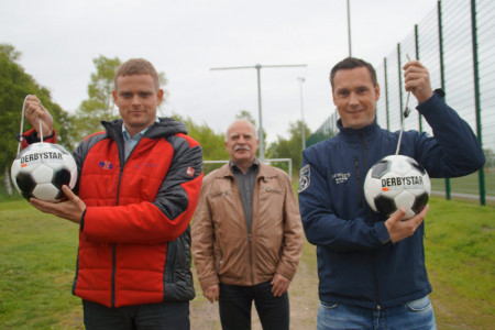Matthias Neumann von MZS übergibt das Kopfballpendel an Klaus Bartsch und Mike Frahm (v.l.) vom SV Warnemünde Fußball.