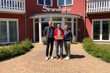 Die Inhaber des Strandhafer Aparthotels, Dorett und Christian Scheil, fühlen sich dem SV Warnemünde Fußball e.V. seit vielen Jahren verbunden. Vorstandsmitglied Mike Frahm (mitte) freut sich über die großzügige finanzielle Unterstützung.