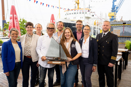 Gemeinsam f&uuml;r die 35. Hanse Sail: Bei der Pressekonferenz zum maritimen Jubil&auml;umsfest freuen sich (v.l.) Bettina Fust, Eva-Maria Kr&ouml;ger, Norbert Leisegang, Jaap van der Rest, Samuel Drews, Marieke van der Rest, Ronny L&ouml;wendei, Kathrin Heitmann und Martin Paul Rose, Fregattenkapit&auml;n Martin-Paul Rose, Kommandeur des Marinest&uuml;tzpunktkommandos, auf vier Tage voller Traditionsschiffe und neue Impulse.//Foto: TZRW, Holger Martens