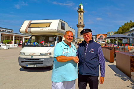 Der Warnemünder Leuchtturm war der 100. im Reistagebuch von André Kroboth (l.). Empfangen genommen hat ihn hier Leuchtturmmann Hartmut Kellner.