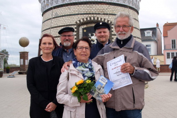 Für das Urlauberpaar Bärbel und Manfred Forwerk ist es der erste Besuch auf dem Warnemünder Leuchtturm. Inge Morenz, Klaus Möller und Mathias Stagat begrüßen die Jubiläumsgäste (hintere Reihe v.l.).  