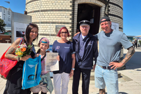 Maria Lau (l.) mit Tochter Nele, 30.000. Besucherin des Jahres 2026, und Raymond Wilhelm (r.) aus Sachsen wurden von Inge Morenz und Bernhard Autrum vom Leuchtturmverein herzlich empfangen.