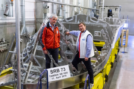 Dr. Helmut Elsner legt unter den Augen von DGzRS-Inspektor Carl G&ouml;ner (li.) eine Zehn-Euro-Gedenkm&uuml;nze von 2008 zum 50. Geburtstag des Segelschulschiffs &bdquo;Gorch Fock&ldquo; in eine Sektion des Seenotrettungsbootes SRB 73 ein. Elsners 2016 verstorbener Vater, Gerhard Elsner, hatte die Seenotretter in seinem Nachlass gro&szlig;z&uuml;gig bedacht und damit ma&szlig;geblich zur Finanzierung des Neubaus beigetragen.