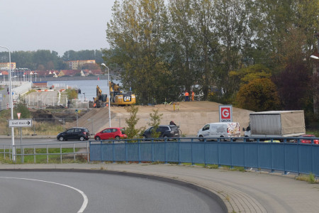 Der &bdquo;Erdhaufen&ldquo; vor dem Werftgel&auml;nde bildet die so genannte Auflastsch&uuml;ttung zur Befestigung des Baugrunds. Damit werden m&ouml;gliche Setzungen aus der sp&auml;ter aufgebrachten Bauwerkslast mit Umrichter- und Trafostation vorweggenommen. 