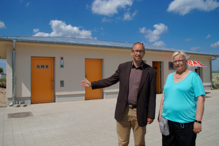 Tourismuschef Matthias Fromm und Service-Mitarbeiterin Doreen Meß vor der neuen Toiletten- udn Duschanlage am Aufgang 6.