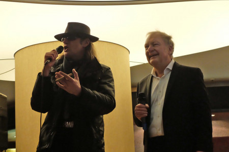"Udo Lindenberg" alias Ansgar Hüttenmüller im Gespräch mit Andreas Dietz auf der Bühne in der Hotellobby.