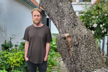 Joakim Blattmann im Innenhof des Edvard-Munch-Hauses – an der Seite des legendären Birnbaums, der Edvard Munch einst inspirierte und nun selbst zum Klangkörper geworden ist.//Foto: Munch-Haus-Warnemünde