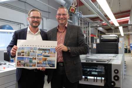 Mehr als zufrieden mit dem Ergebnis: Hotel Neptun-Marketingchef Mario Derer und Druckerei-Geschäftsführer Norbert Hahn präsentieren die aktuellen Postkartenmotive, versehen mit verschiedensten Veredelungseffekten.