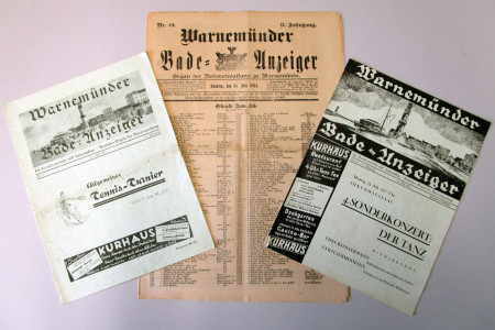 Das Foto zeigt drei im Bestand des Heimatmuseums befindliche Bade-Anzeiger. In der Mitte ist einer der ältesten von 1894 mit der Badeliste gleich vorn auf dem Titelblatt zu sehen.