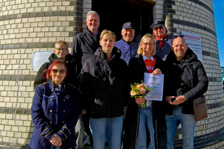 Anja und Guido Haak genießen mit ihren Söhnen Paul (12) und Carl (14) die Herbstferien in Warnemünde. Die Hallenserin wurde von Inge Morenz (u. l.), Mathias Stagat (o. l.), Uwe Billerbeck (o. m.) und Peter Ahrendt (o. r.) herzlich als 70.000. Leuchtturmbesucherin des Jahres empfangen.