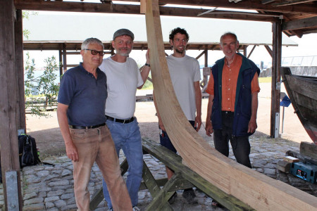 Die Bootsbauer Heribert Hartleib, Uwe Ahlgrimm, Paul und Kristian Brümmer mit dem Kiel der Warnemünder Jolle.