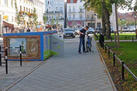 Ein junger Mann leiht sich an der Pedelec-Station am Warnemünder Kirchenplatz ein E-Fahrrad aus.