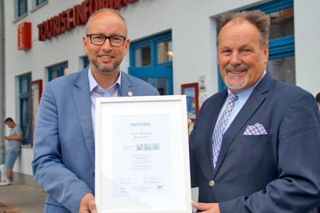 Tourismusdirektor Matthias Fromm (l.) nimmt die Auszeichnung &bdquo;Reisen f&uuml;r Alle&ldquo; f&uuml;r die Tourist-Information von Bernd Fischer, Gesch&auml;ftsf&uuml;hrer Tourismusverband Mecklenburg-Vorpommern, entgegen.