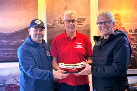 Mit einem Lächeln für den guten Zweck: Uwe Kleinhans (l.) und Jörg Hoppe (r.) übergeben das prall gefüllte Spendenschiffchen an Seenotretter Jörg Westphal.//Foto: Privat