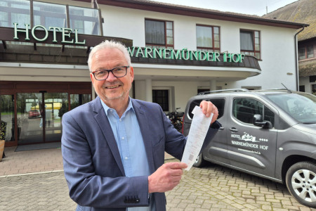 Hoteldirektor Frank Martens zeigt symbolisch einen Tankbeleg f&uuml;r das neue Arrangement &bdquo;Komplett auftanken&ldquo; im Ringhotel Warnem&uuml;nder Hof &ndash; hier beginnt der Urlaub bereits mit einer vollen Tankf&uuml;llung.