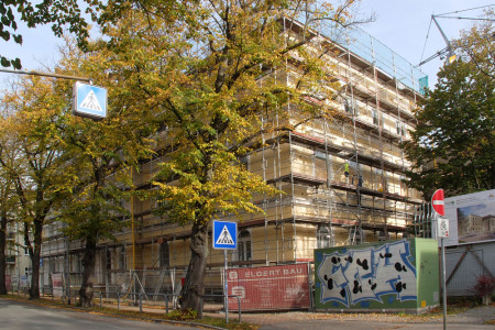 Noch sind Hauptgebäude (Foto 1) und Erweiterungsbau (Foto 2) der Heinrich-Heine-Schule in Warnemünde verhüllt. Die Arbeiten gehen gut voran und schon Anfang November soll über dem Neubau die Richtkrone schweben.