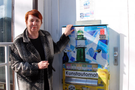 Die Warnemünder Galeristin Ulrike-Sabine Möller vor ihrem Kunstautomat.