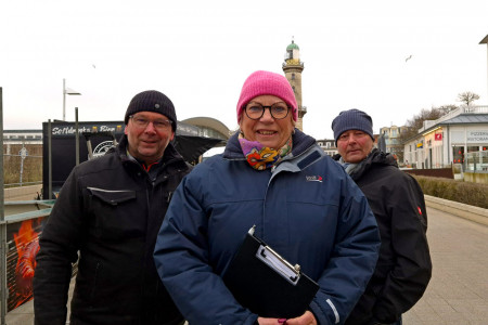 Noch ist es ruhig am Turm (v.l.): Heiko Lange, Anke Lange und Torsten Sitte vor dem Warnem&uuml;nder Leuchtturm &ndash; bevor Genussmeile und Turmleuchten tausende G&auml;ste anziehen.