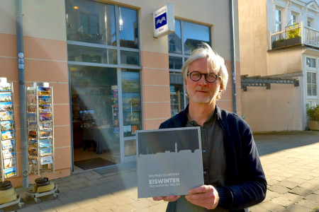 Frank Weisleder, Inhaber der Buchhandlung Möwe in Warnemünde, präsentiert den außergewöhnlichen Bildband „Eiswinter – Warnemünde 1962/63“ – eine Hommage an den Jahrhundertwinter, als die Ostsee erstarrte und Geschichte schrieb.