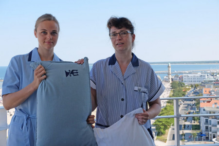 Neptun-Zimmerfrau Andrea Horn (r.) unterweist Schauspielerin Friederike Drews in der Kunst des Bettenaufschüttelns.