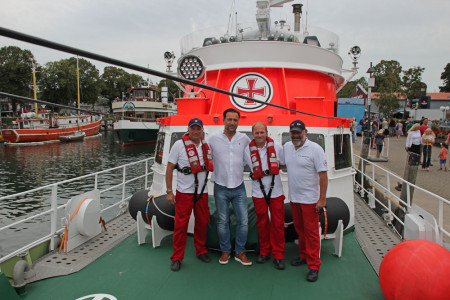 Vormann Uwe Radloff, Nihat &Uuml;nl&uuml;, Maschinist Andreas Heim und Maschinist Steffen Schmei&szlig;er (v.l.) bei der heutigen &Uuml;bergabe von zwei funkelnagelneuen Rettungswesten an Bord des Seenotkreuzers &bdquo;Vormann Jantzen&ldquo;. Das Schiff liegt w&auml;hrend der 29. Hanse Sail im Alten Strom von Warnem&uuml;nde.