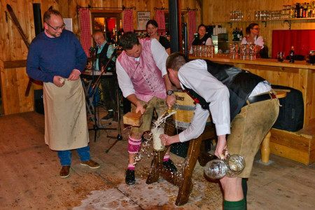 Rostocks Chef-Touristiker Matthias Fromm (li.) lässt sich in der Warnemünder Almhütte durch a-ja-Geschäftsführer Holger Hutmacher zeigen, wie ein Fass Bier angeschlagen wird.