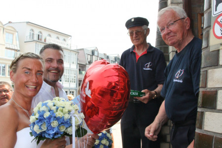 Das Brautpaar Anja und Björn Jülich wird durch die beiden Leuchtturmmänner Walter Vogt (re.) und Heinz Plautz in Empfang genommen.