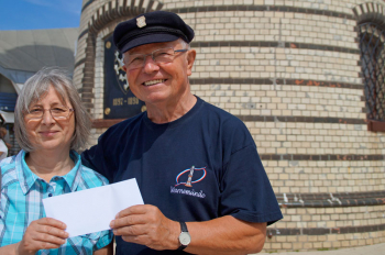 Leuchtturm-Schatzmeister Walter Vogt übergibt einen mit 300 Euro gefüllten Umschlag an Küsterin Silvia Schmidt.