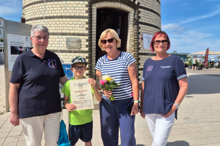 Strahlende Gesichter vor Warnem&uuml;ndes Wahrzeichen: Gemeinsam mit seiner Oma Heidemarie Lehmann (2.v.r.) freut sich Jubil&auml;umsbesucher Diego Cadisch &uuml;ber den Besuch des Leuchtturms. In Empfang genommen wurde er durch die designierte Schatzmeisterin Karin M&ouml;ller (l.) und Inge Morenz vom F&ouml;rderverein Leuchtturm Warnem&uuml;nde.