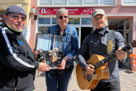 Doc Andreas Buhse, die Künstlerin, Karin Krüger, und Musiker Ola Van Sander  (v.l.)vor dem Coaast Schallplattencafé am Warnemünder Leuchtturm. Hier hat gefilzte Skulpturengruppe auf dem Verkaufstresen ihren Platz gefunden.//Foto: Maria Pistor