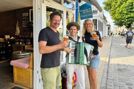 Herzlich willkommen zur Warnem&uuml;nder Woche: Sylvia und Henry Gidom freuen sich gemeinsam mit Akkordeonist Max Nadzeika auf einen stimmungsvollen Musiknachmittag vor dem Hoppen un Molt Store.//Foto: Privat