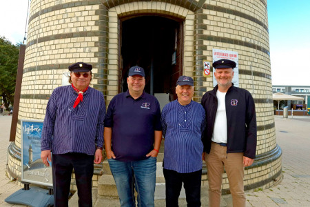 Der offizielle Botschafter des Warnemünder Leuchtturmvereins, André Kroboth (2.vl.l.), wird durch die Leuchtturmmänner Peter Ahrendt (l.), und Uwe Billerbeck (2.v.r.) sowie Leuchtturmchef Mathias Stagat willkommen geheißen.
