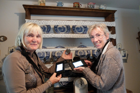 Doris Reiber vom Museumsverein und die Leiterin des Heimatmuseums, Dr. Kathrin Möller, testen den neuen Audoguide anhand eines Warnemünder Brotstempels.