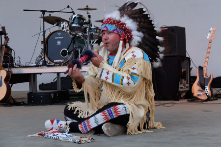 Ein Hingucker: Musiker, Schnellzeichner und Indianerfan Olaf Hobrlant im selbsthergestellten Häuptlingsdress pafft auf der Bühne an einer Friedenspfeife.