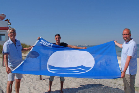 Bei Traumwetter hissen Henry Klützke, Manuel Brumme und Matthias Fromm am Strandaufgang 23 in Markgrafenheide die Blaue Flagge. Das internationale Qualitätssiegel wurde zum 25. Mal verliehen.