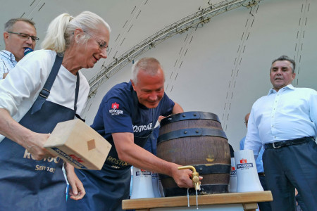 Bürgerschaftspräsidentin Regine Lück wird von Braumeister Uwe Kästner beim Fassbieranstich unterstützt. Wilfried Ott, Geschäftsführer der Hanseatischen Brauerei Rostock (r.) freut sich, die Warnemünder Woche auch in diesem Jahr unterstützen zu dürfen.
