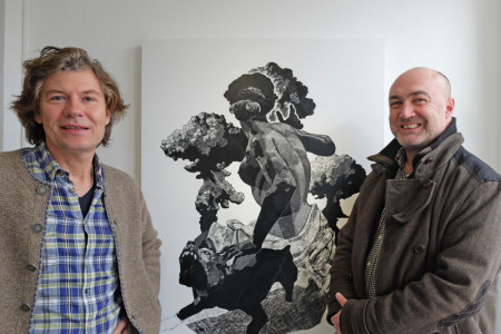 Galerist Alexander Gehrke (li.) mit dem Warnemünder Künstler Rando Geschewski vor dessen Werk "Atomschlag mit Hund". Hier wurde zuvor aufgetragene Tusche mit einer Rasierklinge wieder abgekratzt.