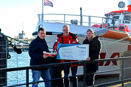 Seenotretter Jörg Westphal (mitte) freut sich über einen 1.000 Euro Spendenscheck, überreicht durch Bruno Seifert (l.) und Axel Schulz von der Aquametro Oil & Marine GmbH aus Warnemünde.